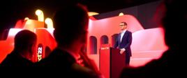 Minister rozwoju i technologii Waldemar Buda podczas przemówienia premiera Mateusza Morawieckiego otwierającego obrady Impact'22, na zdjęciu scena główna kongresu i stojący przy mównicy premier Mateusz Morawiecki