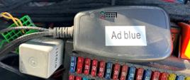 Emulator AdBlue wpięty do instalacji elektrycznej ciężarówki i znajdująca się pod nim skrzynka z bezpiecznikami. 