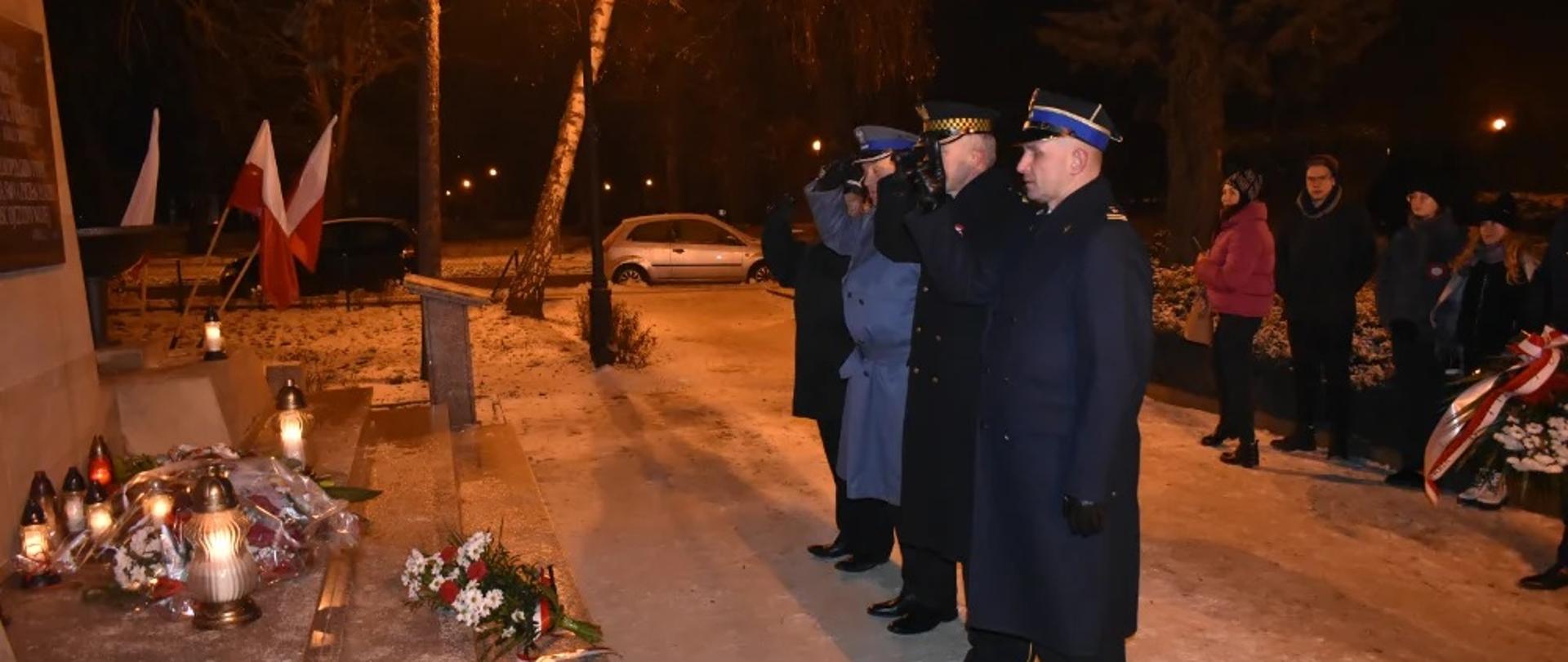 Zdjęcie przedstawia oddających honor przedstawicieli Straży Pożarnej, Policji i Straży Miejskiej przy pomniku Powstańców Wielkopolskich