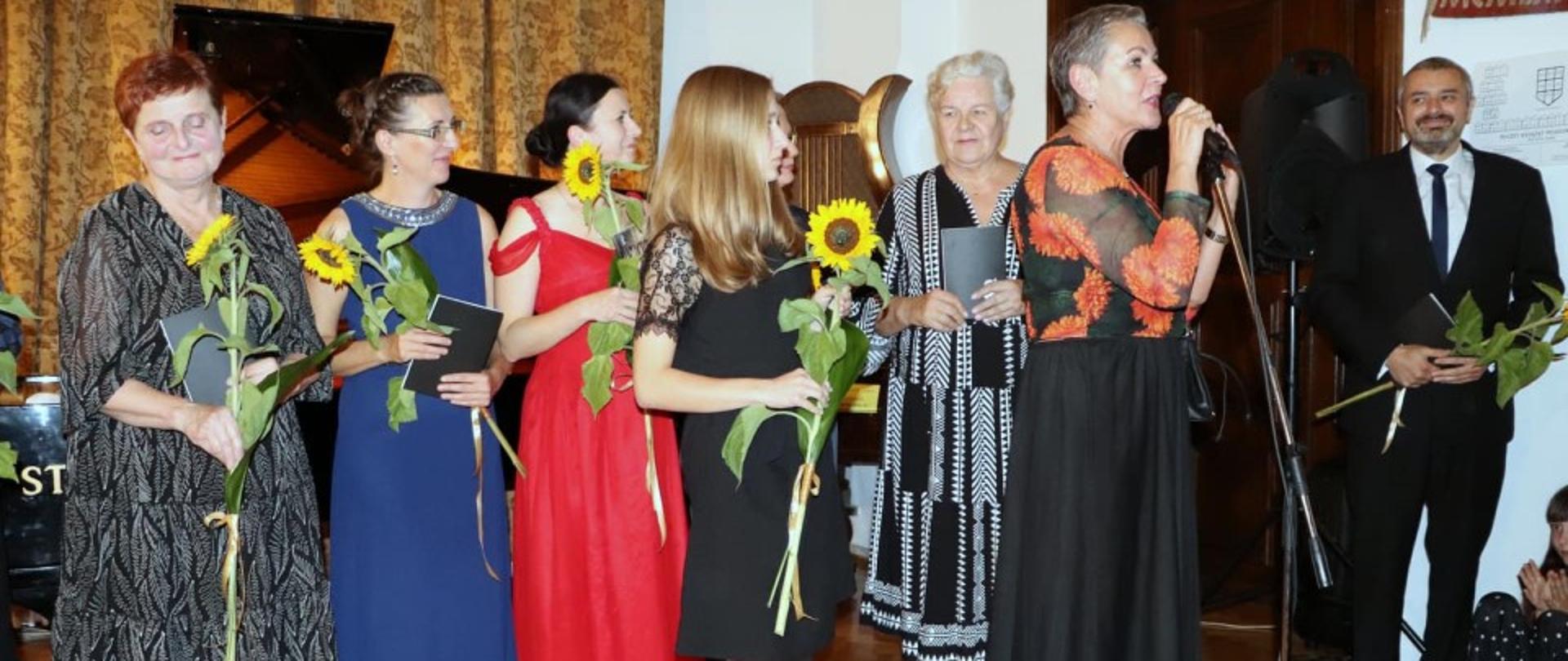 Zdjęcie kolorowe. Grupa muzyków w strojach galowych na scenie Zamku Książąt Pomorskich w Słupsku