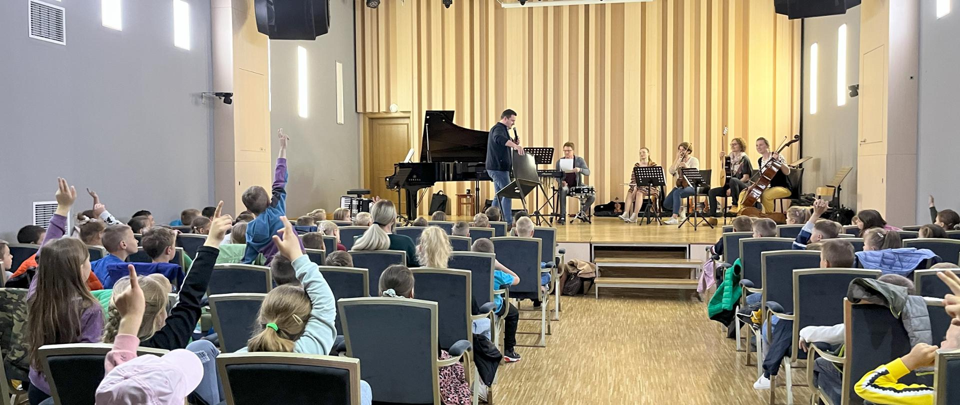 Warsztaty muzyczne w PSM. Galeria zdjęć z warsztatów muzycznych w szkole. Na zdjęciach nauczyciele PSM oraz dzieci ze szkół i przedszkoli.