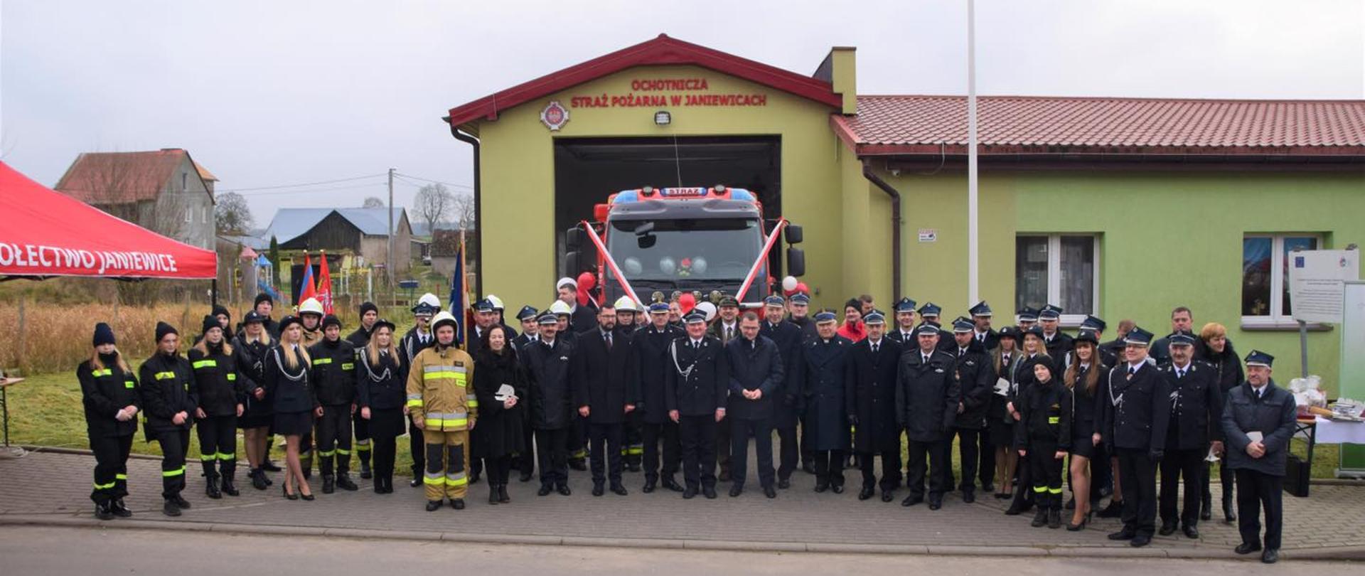 Zdjęcie grupowe na tle remizy OSP