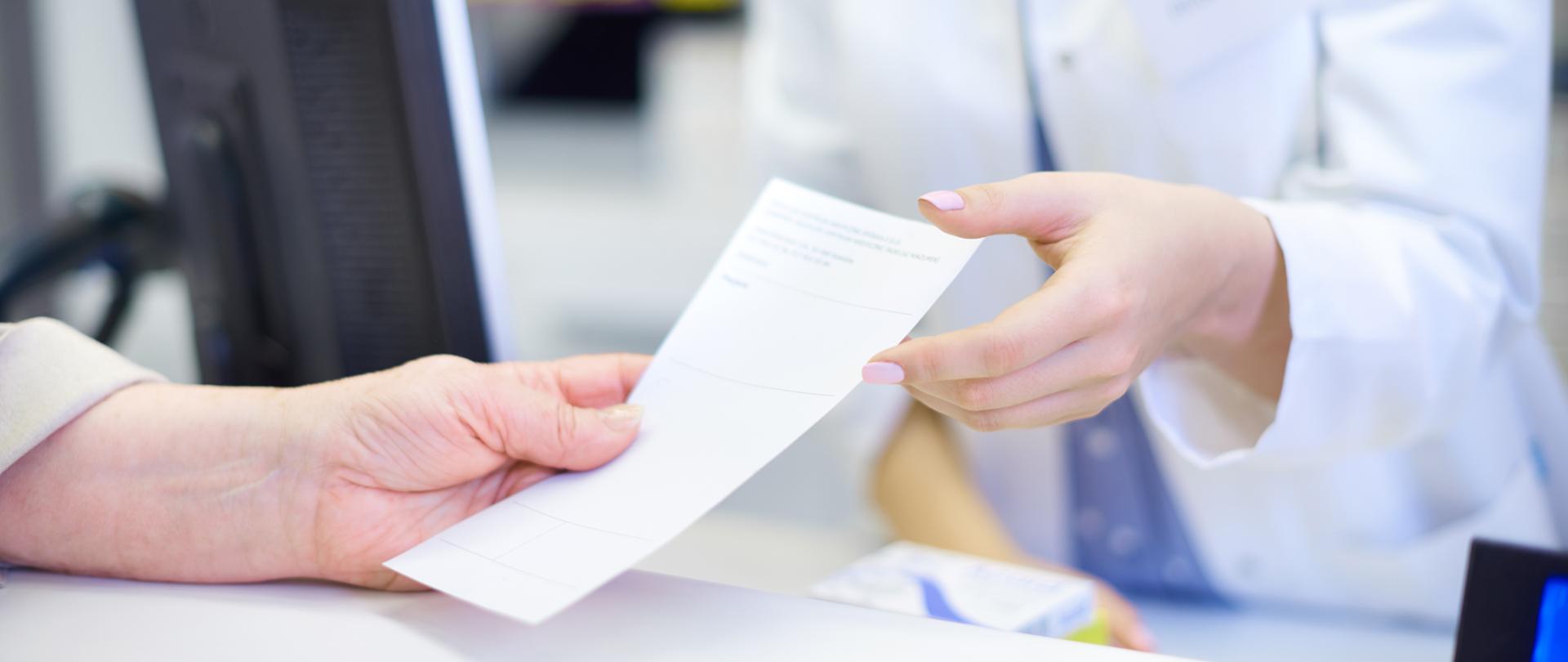 lekarz wręcza receptę pacjentowi
