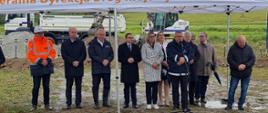 grupa osób stoi pod namiotem: parlamentarzyści, wicewojewoda, minister infrastruktury A. Adamczyk mówi do mikrofonu