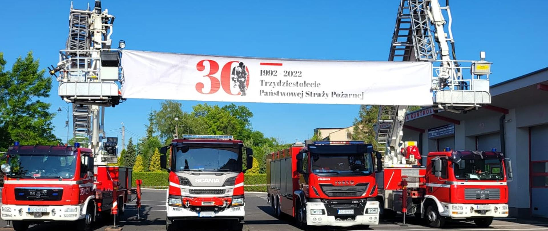 Na zdjęciu widoczne pojazdy pożarnicze oraz baner 30 lecie PSP