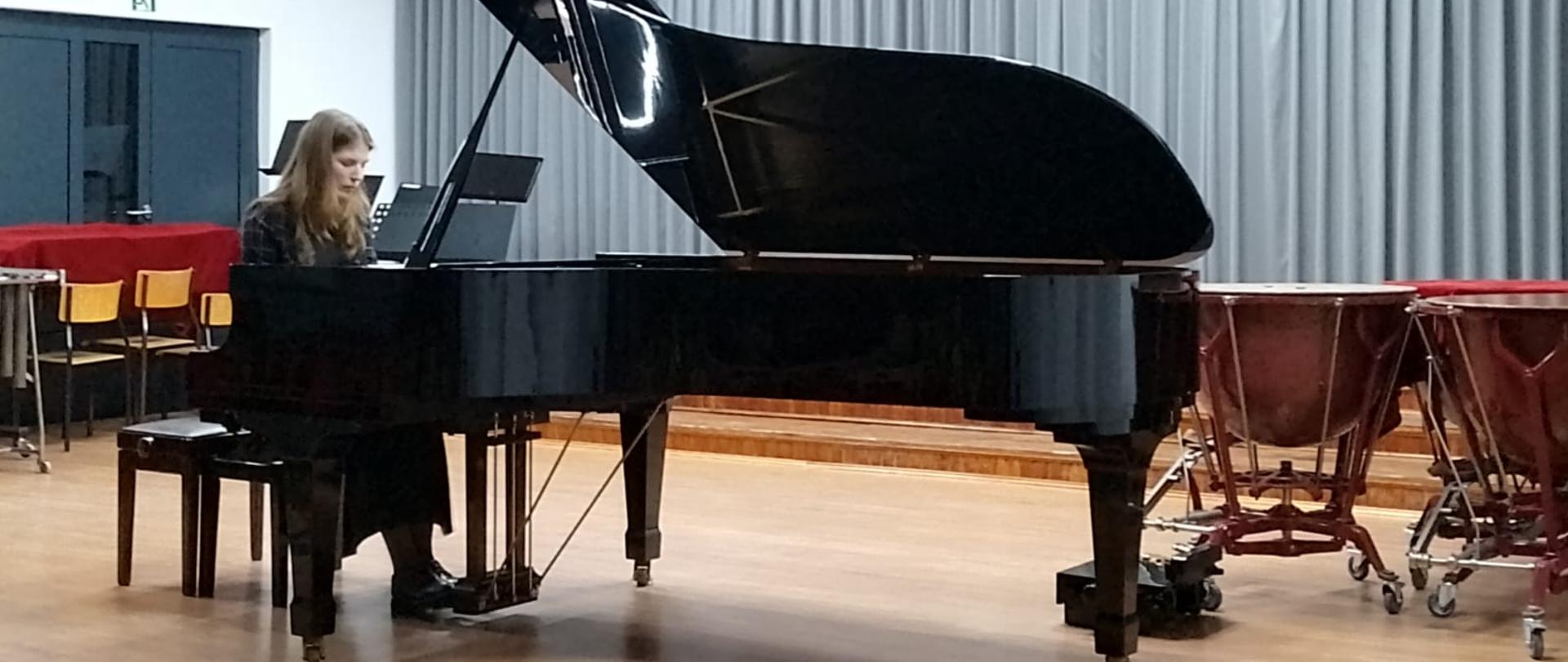 Amelia Bochno gra na fortepianie na scenie szkoły muzycznej w Białogardzie