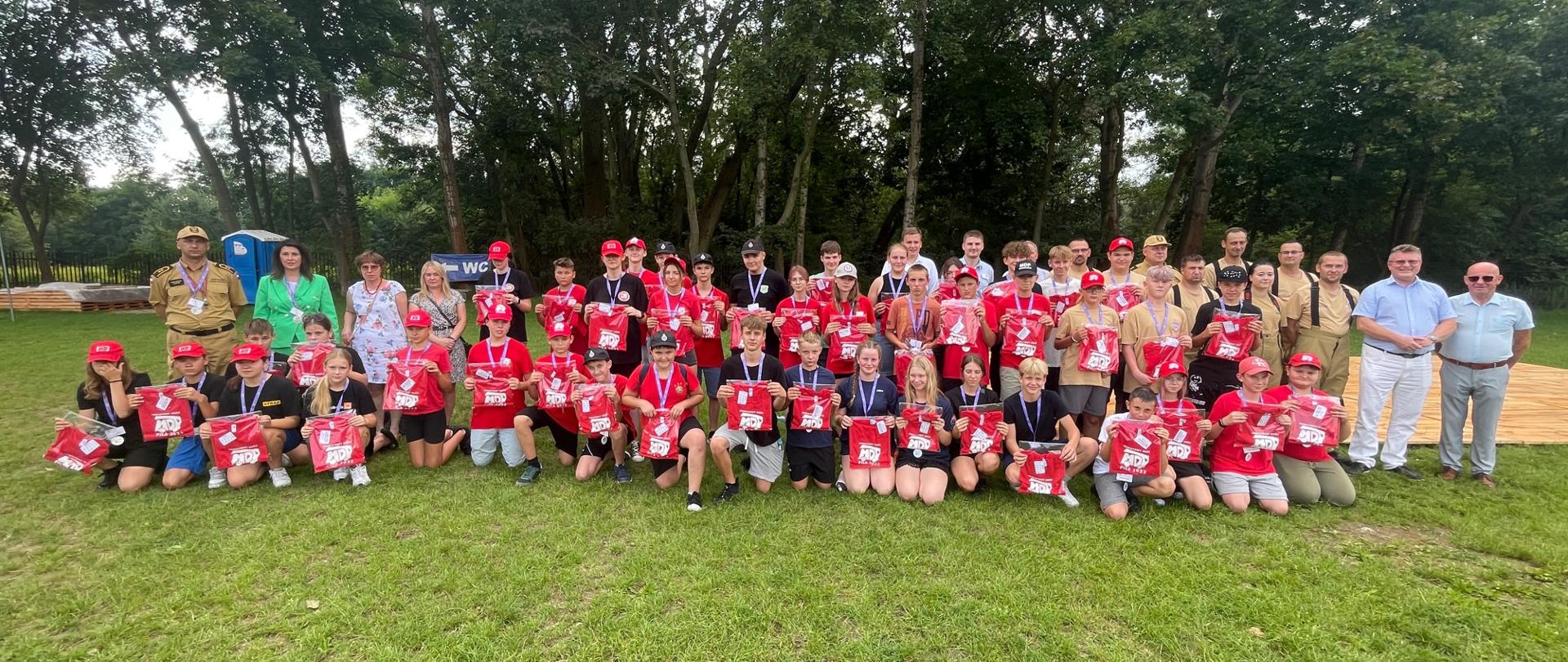 Na zdjęciu widnieją strażacy z młodzieżowych drużyn pożarniczych w trakcie obozu dla młodzieżowych drużyn pożarniczych. 