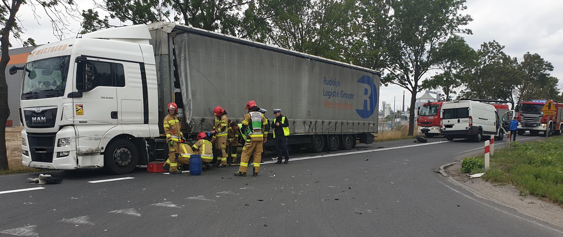 Na zdjęciu widać samochód ciężarowy i strażaków, którzy uszczelniają wyciek paliwa.