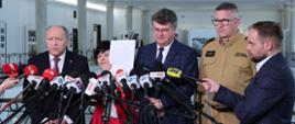 Na zdjęciu widać pięć osób podczas briefingu prasowego w gmachu Sejmu RP