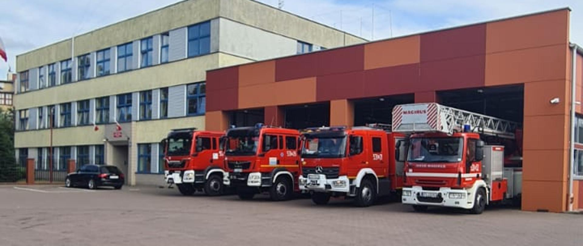 Samochody pożarnicze w bramach wyjazdowych z garażu.
