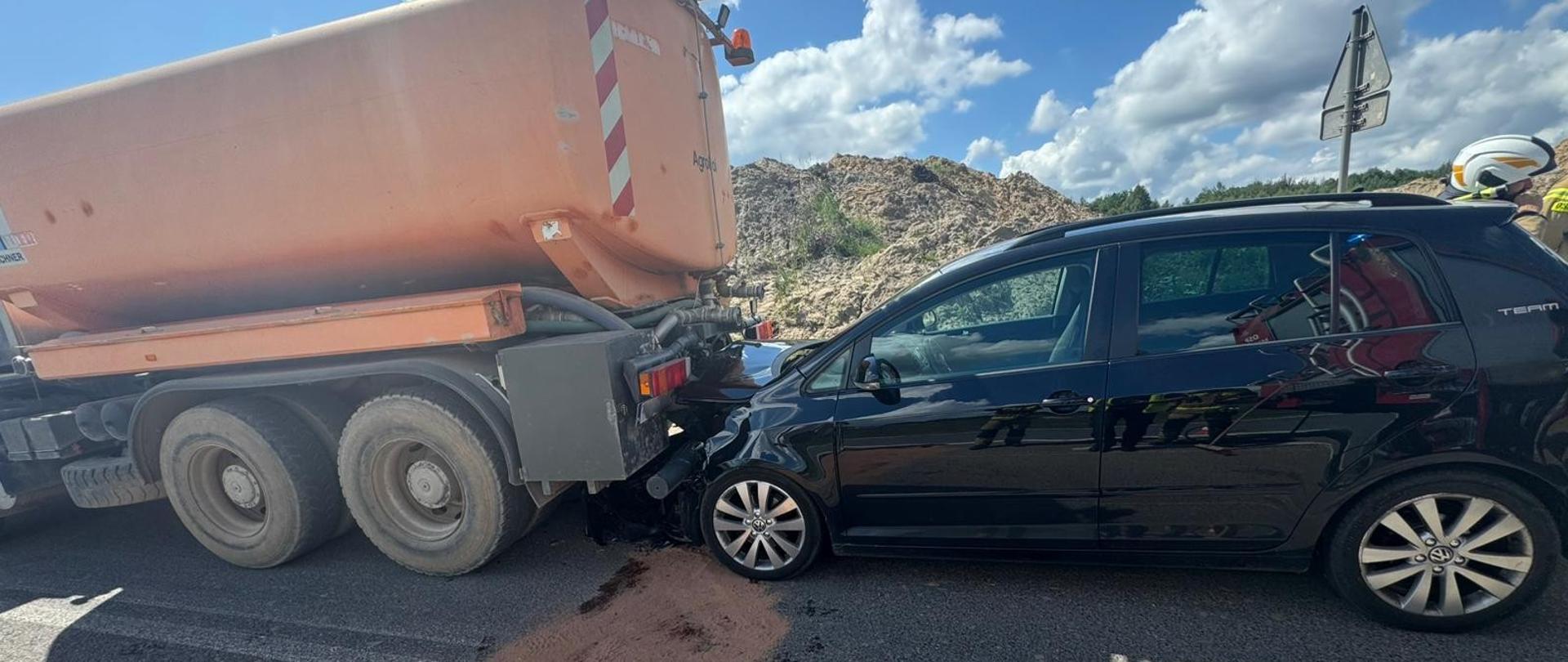 Zdjęcie przedstawia miejsce wypadku: z lewej strony stojąca zamiatarka, a za nią zniszczony samochód osobowy.