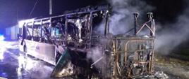 Zdjęcie przedstawia spalony autobus zaparkowany na zatoczce autobusowej