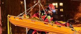 Zdjęcie przedstawia ratownika realizującego założenie ćwiczebne polegające na ewakuacji poszkodowanego z wykorzystaniem kolejki linowej.