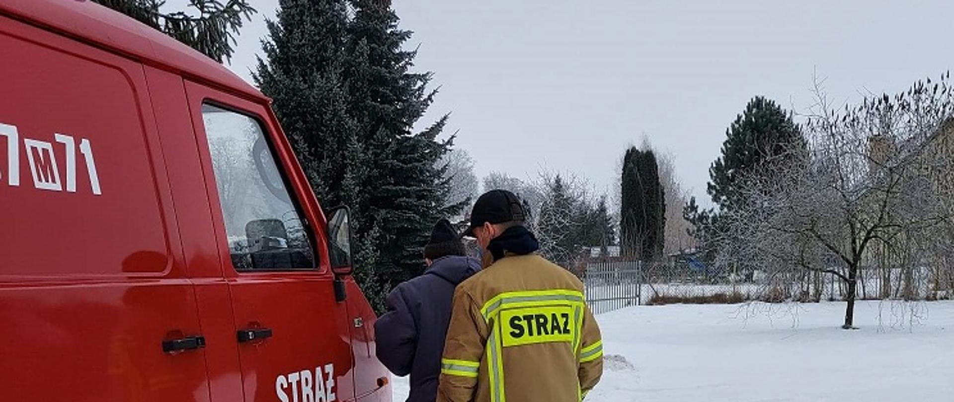 Strażak pomagający starszej osobie w transporcie na szczepienie przeciw COVID-19