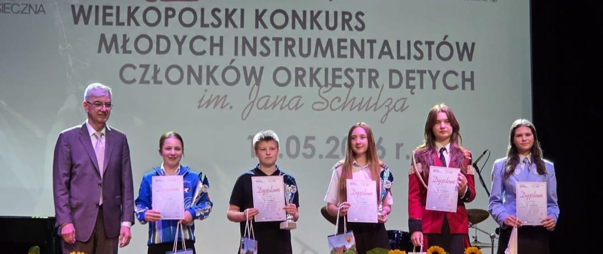 Pięcioro uczniów z dyplomami i upominkami oraz jedna osoba dorosła. W tle tytuł konkursu.