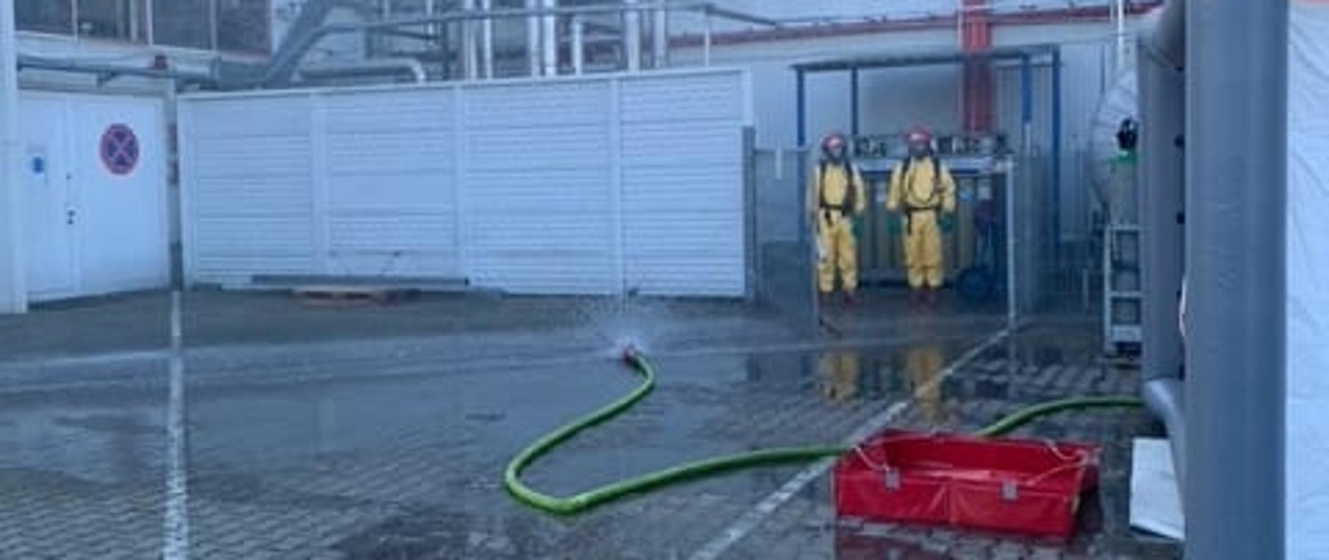 Widać strażaków w oddali podczas dekontaminacji