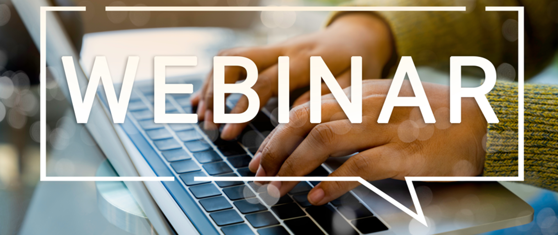 Ręce na klawiaturze laptopa, na pierwszym planie napis webinar