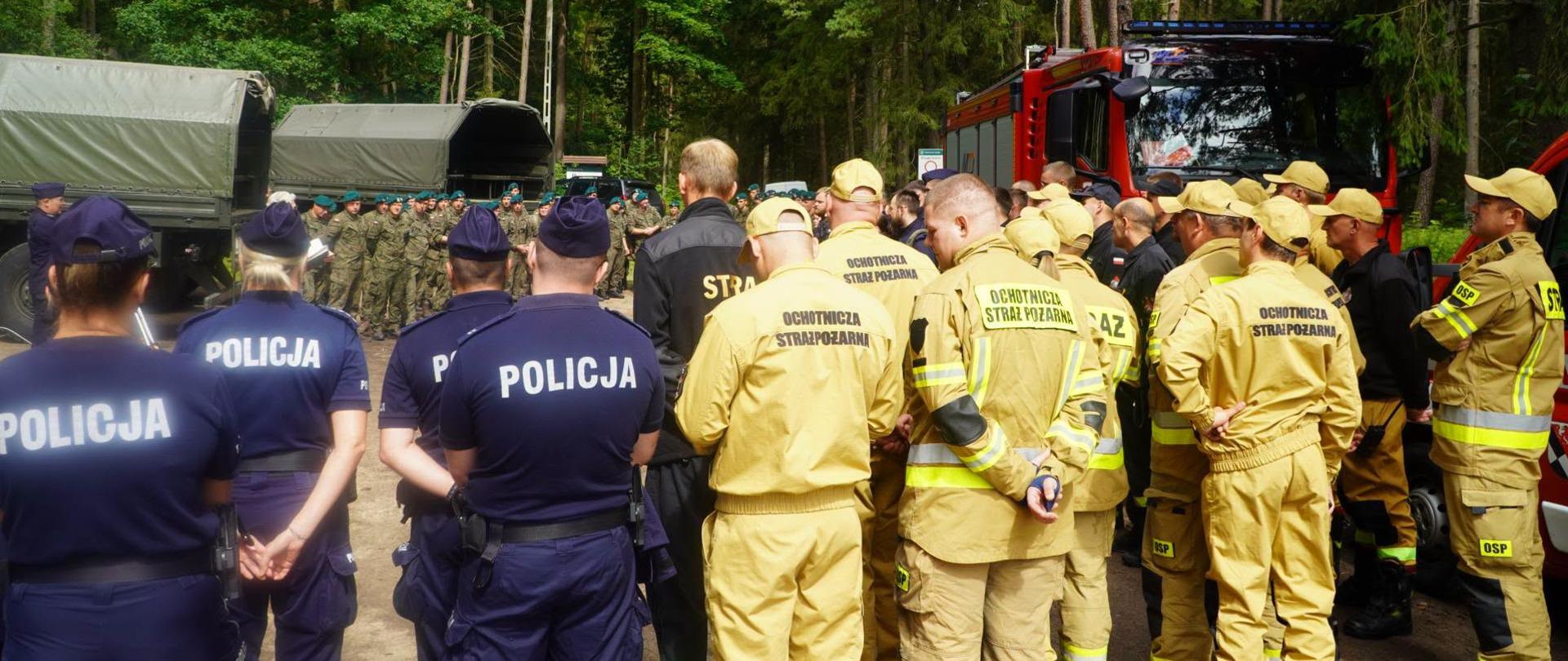 Zdjęcie przedstawia odprawę służb przed podjęciem działań poszukiwawczych osoby zaginionej z innej perspektywy (osób wykonawczych)