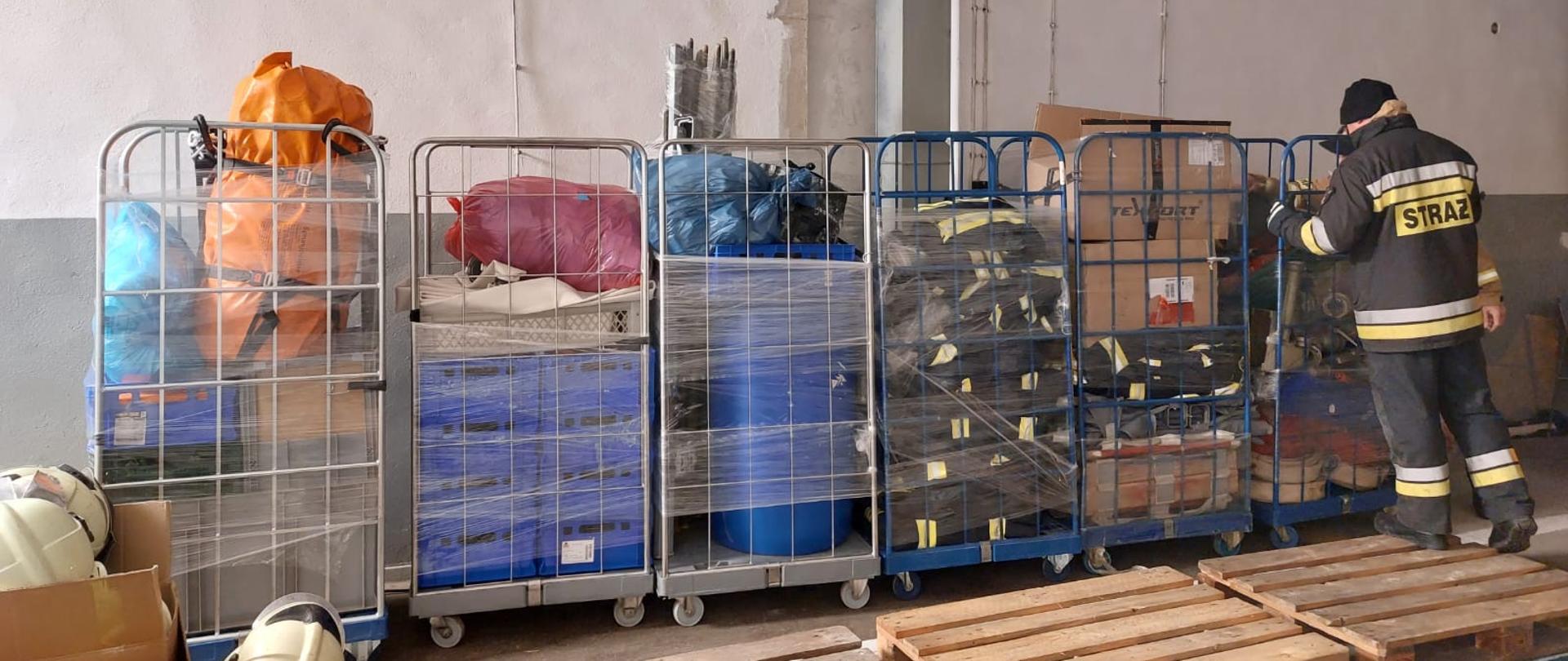 Strażak sortuje przedmioty przed wysłaniem na wschód Polski