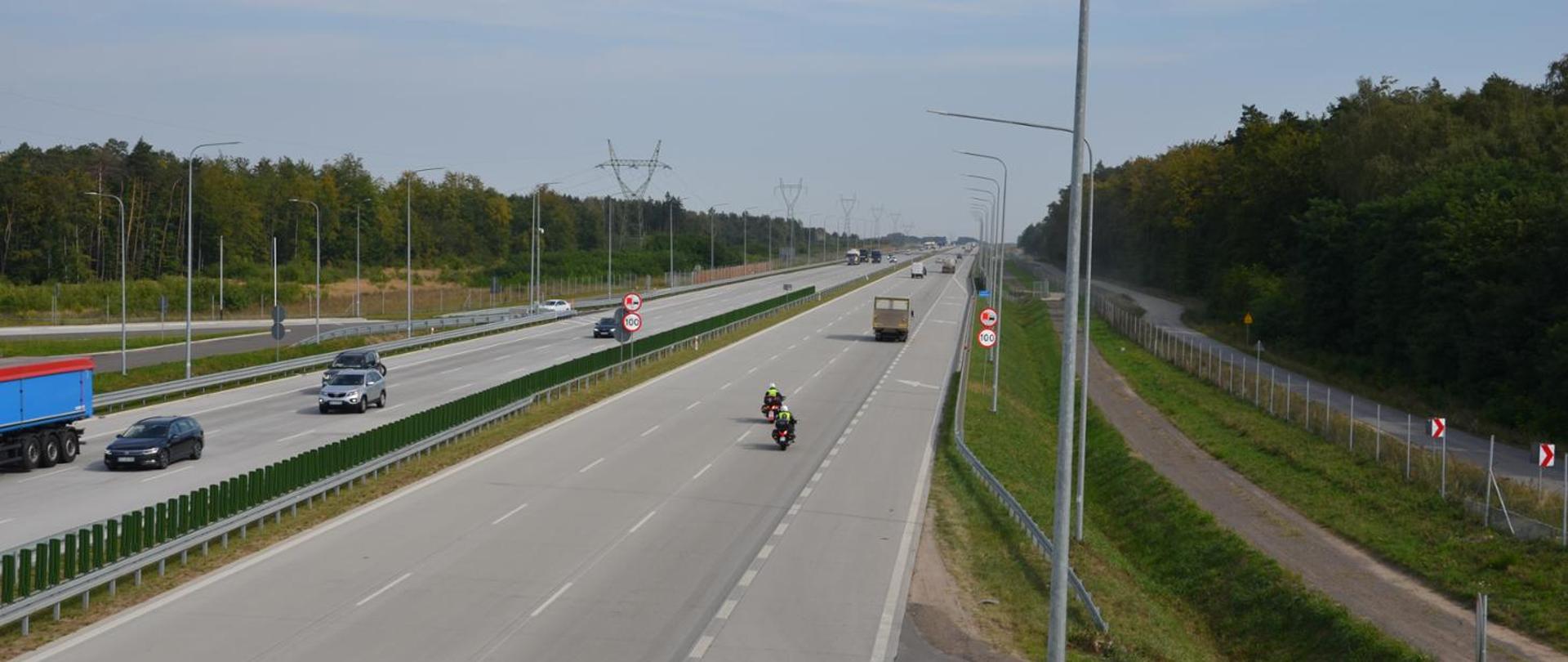 Widok z góry na pojazdy na autostradzie A1. Widoczne wyraźnie ograniczenie prędkości do 100 km/h.