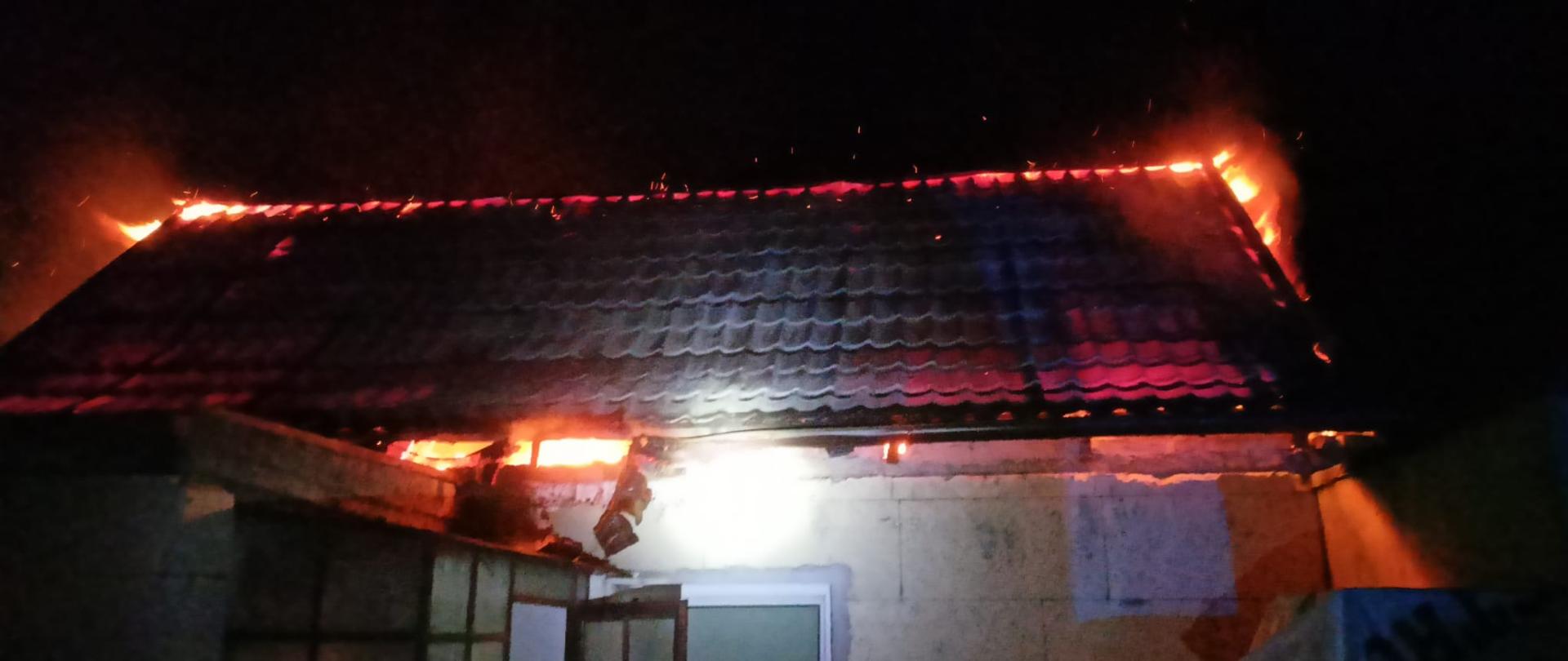 Widać budynek mieszkalny i pożar dachu