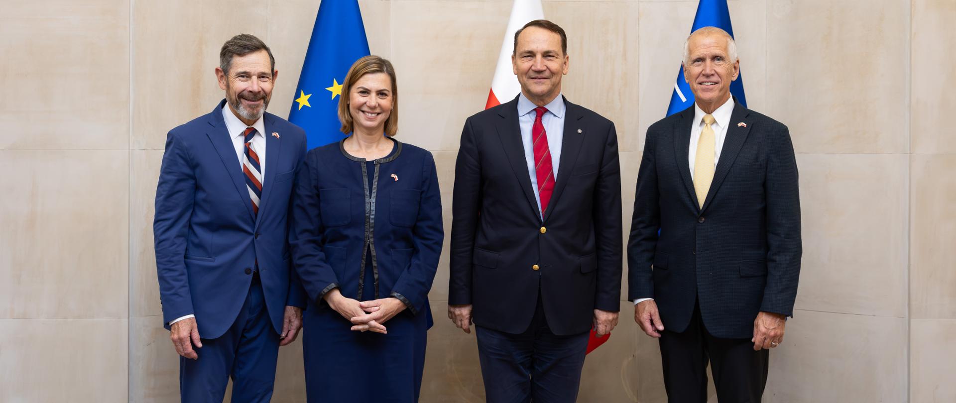 Wicepremier Sikorski i delegacja senatorów USA pozuje wspólnie do oficjalnego zdjęcia. Wszyscy uśmiechają się do kamery.