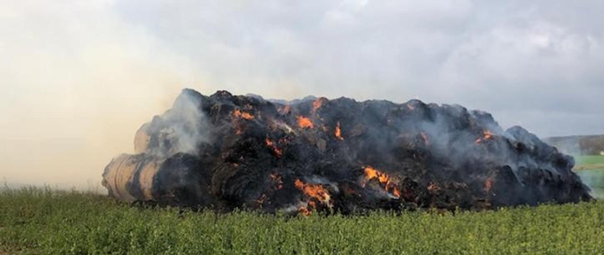 Widok na palącą się stertę balotów słomy