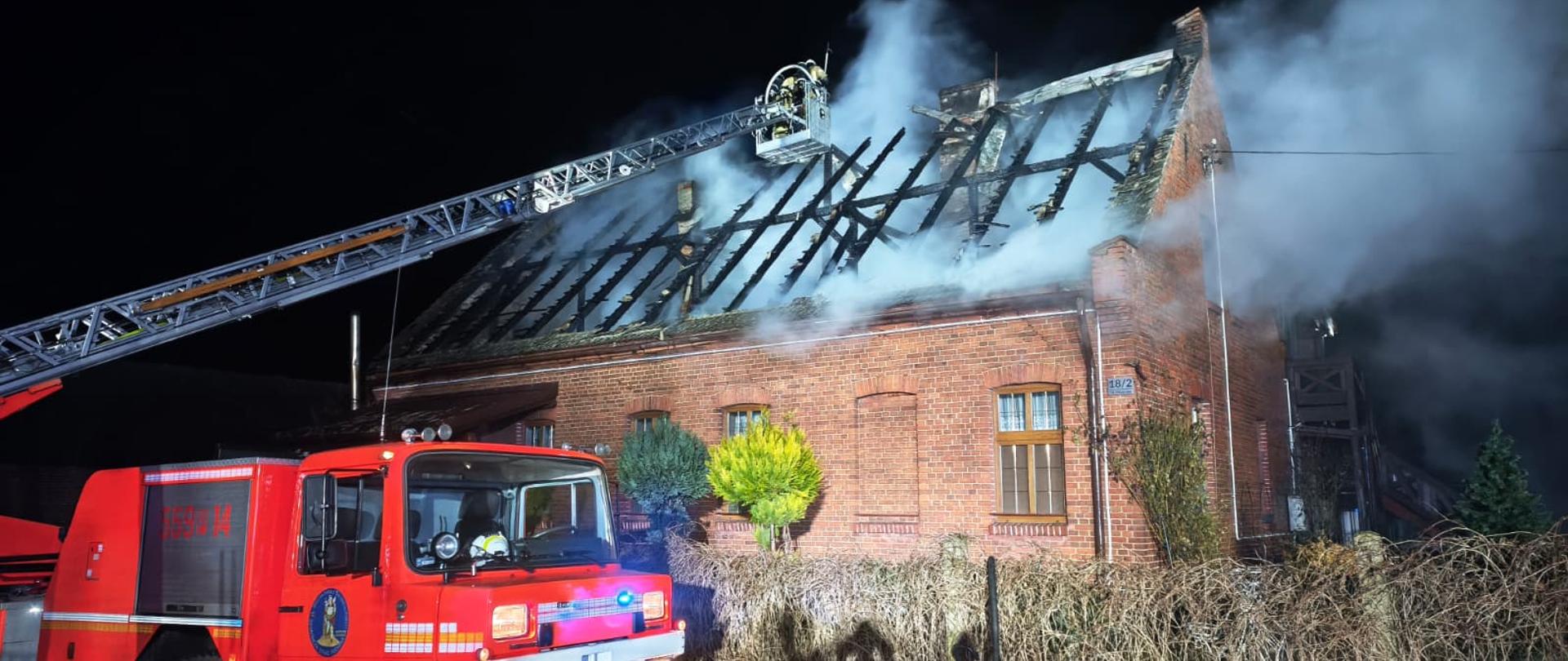 Na zdjęciu widać straż pożarna w trakcie działań gaśniczych podczas pożaru dachu w budynku mieszkalnym. 