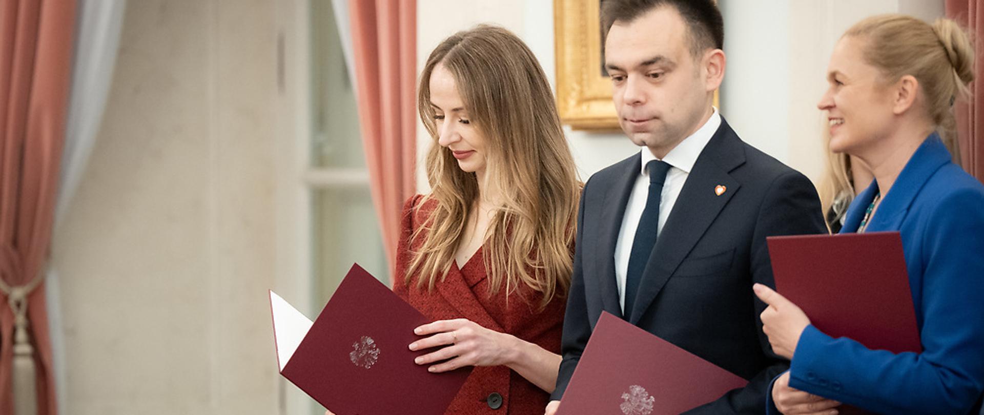 Na zdjęciu Minister Rodziny, Pracy i Polityki Społecznej – Agnieszka Dziemianowicz-Bąk odbierająca powołanie w skład rady Dialogu Społecznego. Obok, po prawej stronie Minister Finansów i Minister Edukacji.