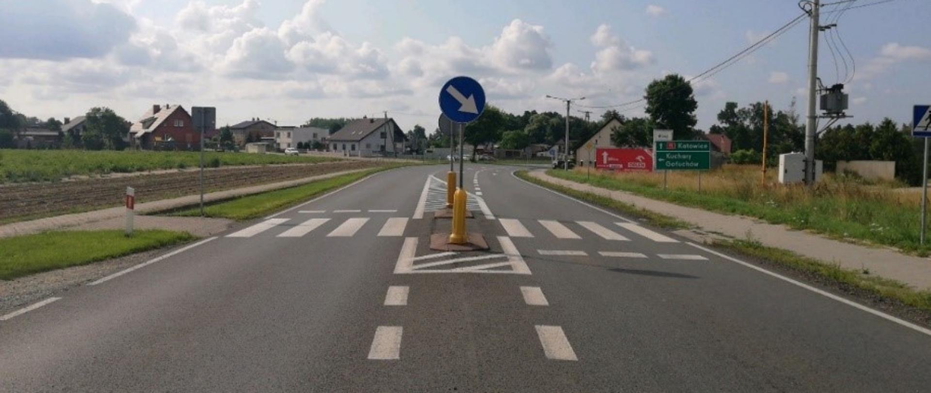 przejście dla pieszych przed wjazdem do miejscowości widoczny azyl na środku drogi