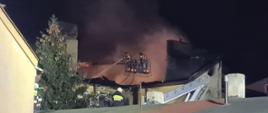 Na zdjęciu widać strażaków, którzy prowadzą działania ratowniczo - gaśnicze z podnośnika.