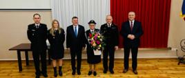 Na pierwszym planie druhna Krystyna Nowak z kwiatami w asyście Posła, Burmistrza i funkcjonariuszy PSP