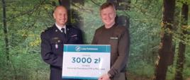 Komendant Powiatowy PSP w Pleszewie wraz z Nadleśniczym Nadleśnictwa Taczanów trzymają wspólnie symboliczny czek na kwotę 3000 złotych
