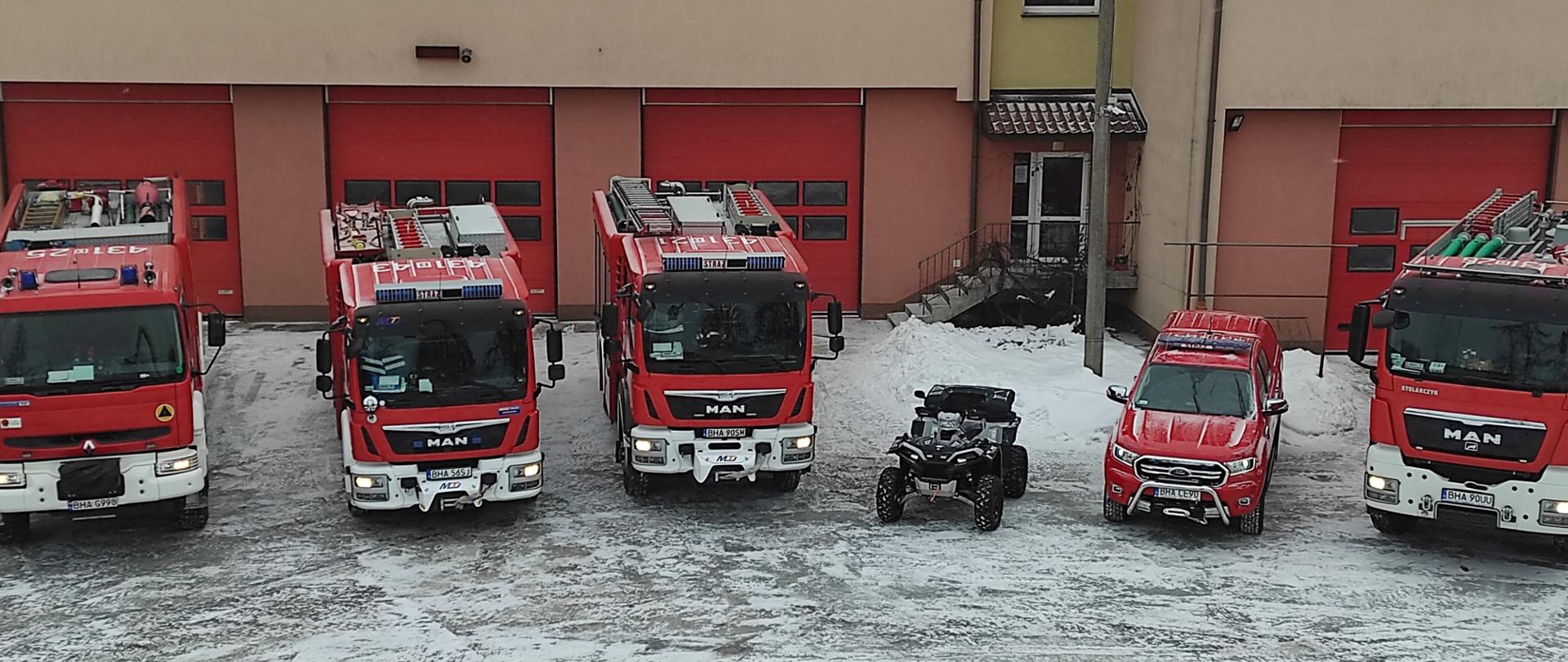 Widoczne z góry pojazdy , samochody gaśnicze na wyposażeniu KP PSP Hajnówka, widoczna pora zimowa, pojazdy na tle budynku KP PSP Hajnówka