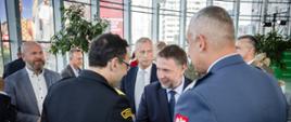 Przedstawiciele Państwowej Straży Pożarnej i innych instytucji witają się podczas oficjalnego spotkania poświęconego współpracy w obszarze bezpieczeństwa.