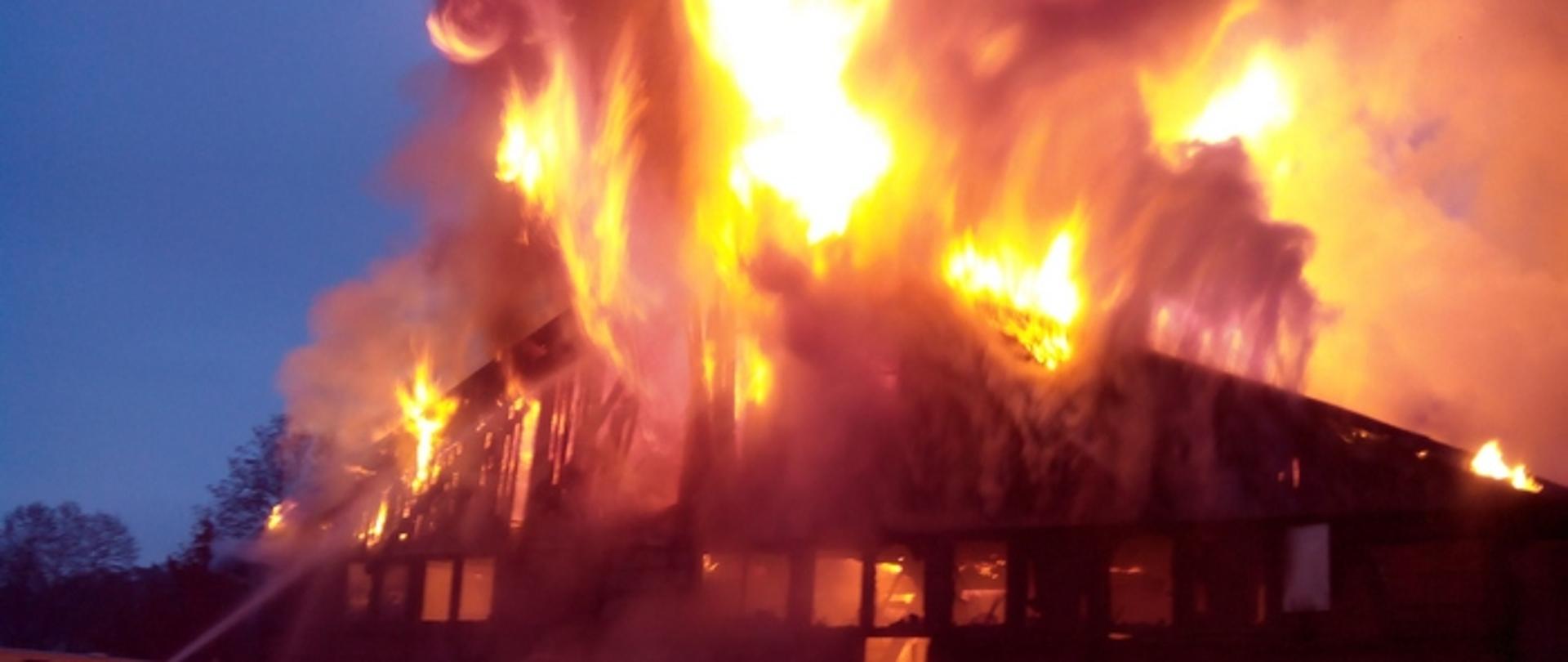 Zdjęcie przedstawia budynek w całości objęty pożarem