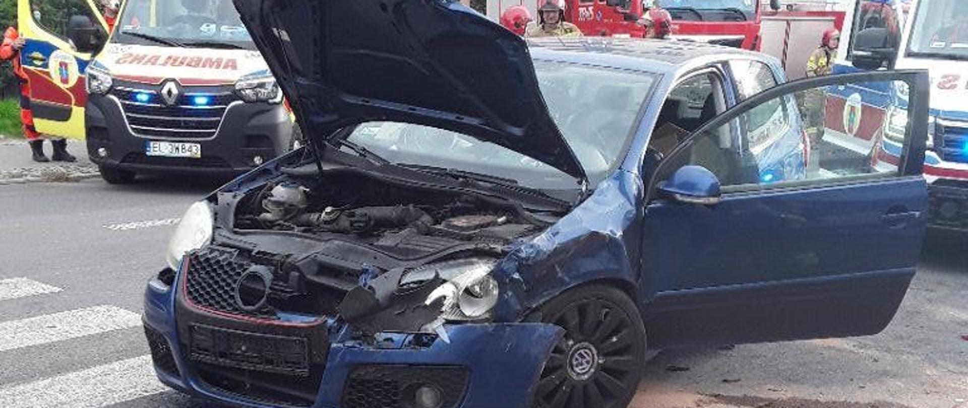 Rozbite auto osobowe w tle karetki pogotowia i samochód pożarniczy 