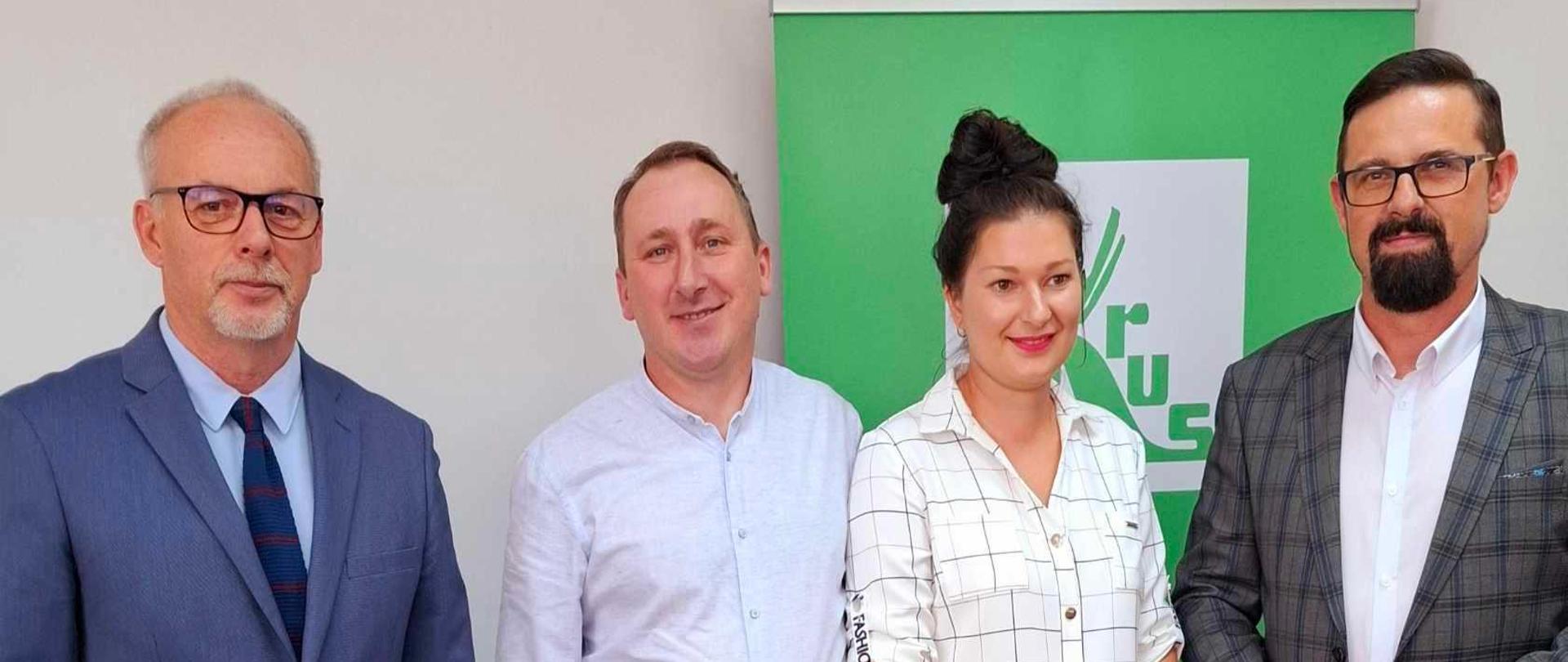 Na zdjęciu trzech mężczyzn oraz jedna kobieta pozują do zdjęcia 