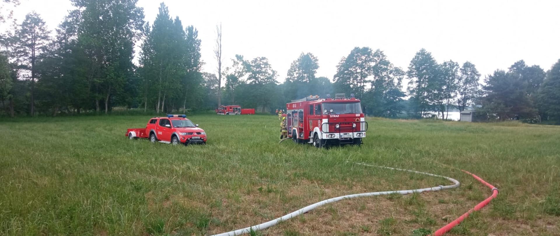Na zdjęciu samochody strażackie w trakcie realizacji ćwiczeń podawania wody na duże odległości