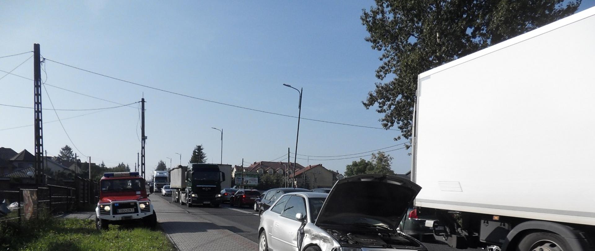 Zdjęcie przedstawia pojazd pożarniczy oraz uszkodzony samochód osobowy