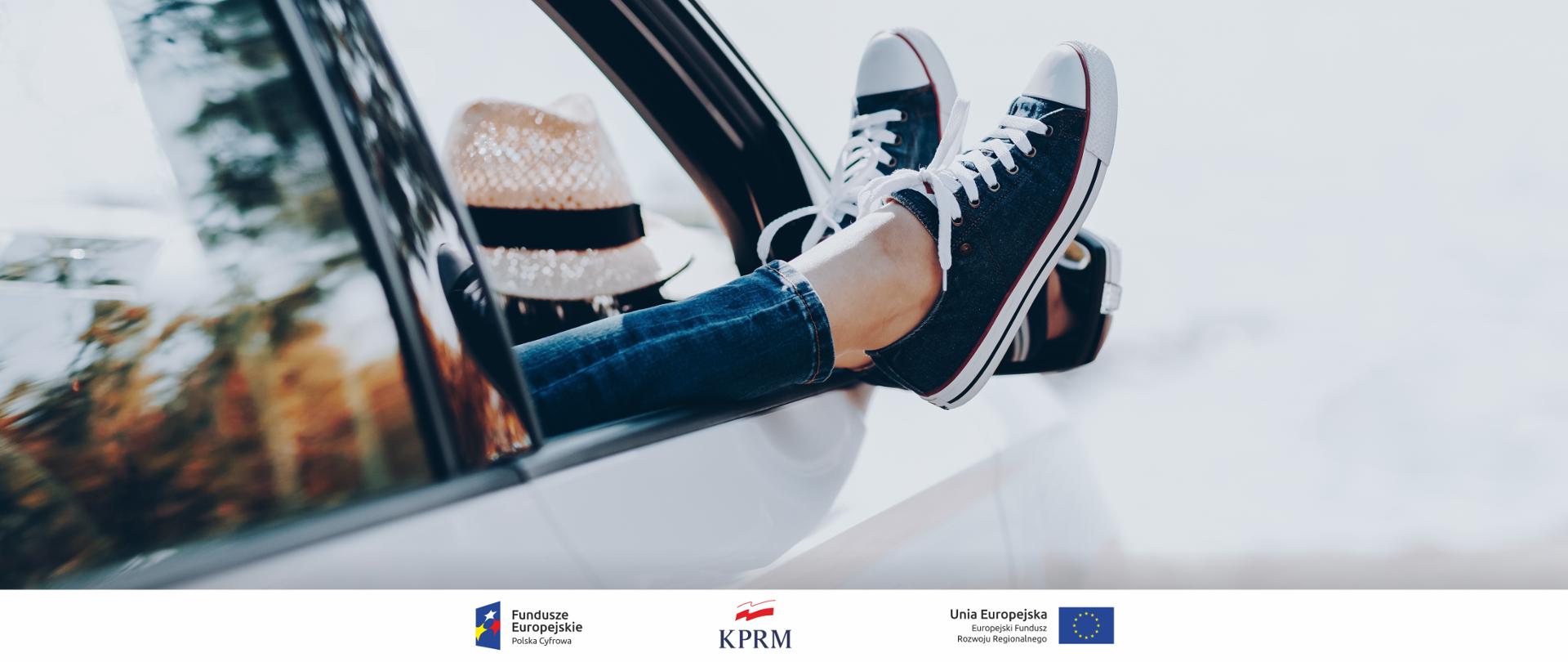 Na zdjęciu widać wystawione przez okno samochodu kobiece nogi. W samochodzie widać słomkowy kapelusz.