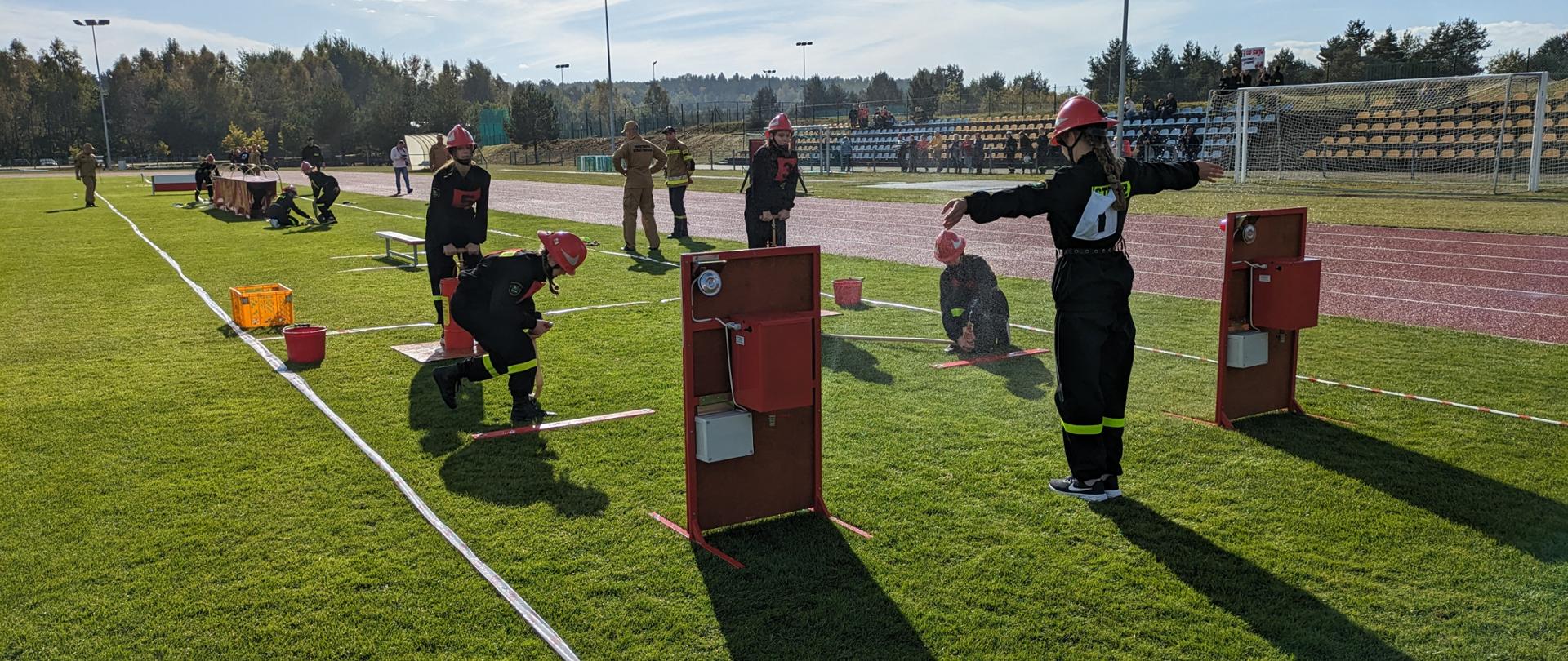 Na zdjęciu młodzieżowa drużyna pożarnicza w trakcie wykonywania ćwiczenia bojowego