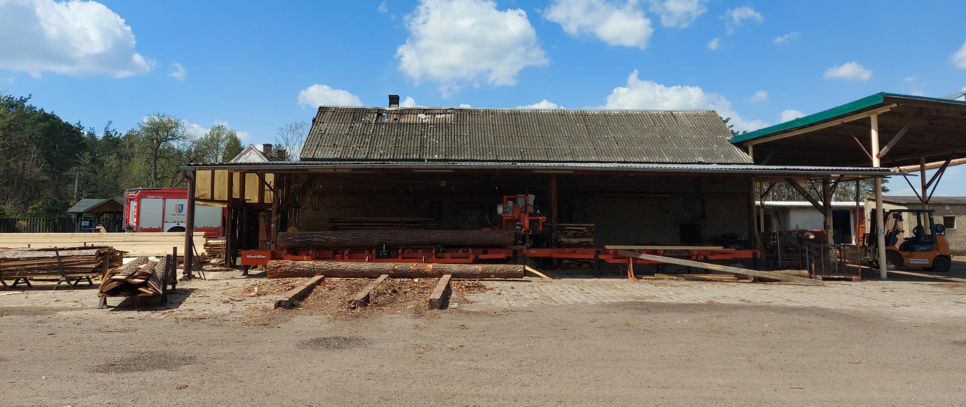 Zdjęcie przedstawia budynek tartaku, w którym miał miejsce pożar. 