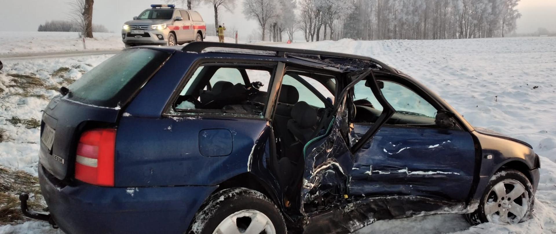  Audi A4 z uszkodzonym prawym bokiem, znajduje się w przydrożnym rowie. 