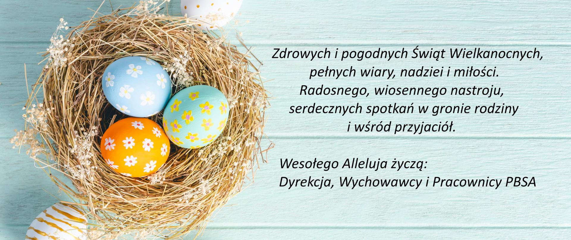 Wielkanoc. Jajka wielkanocne malowane w kwiatki w gniazdku na drewnianym błękitnym tle. Życzenia wielkanocne po prawej stronie obrazka.