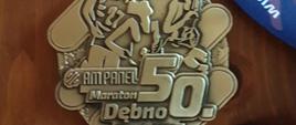 Ilustracja przedstawia otrzymany medal po ukończeniu maratonu.
