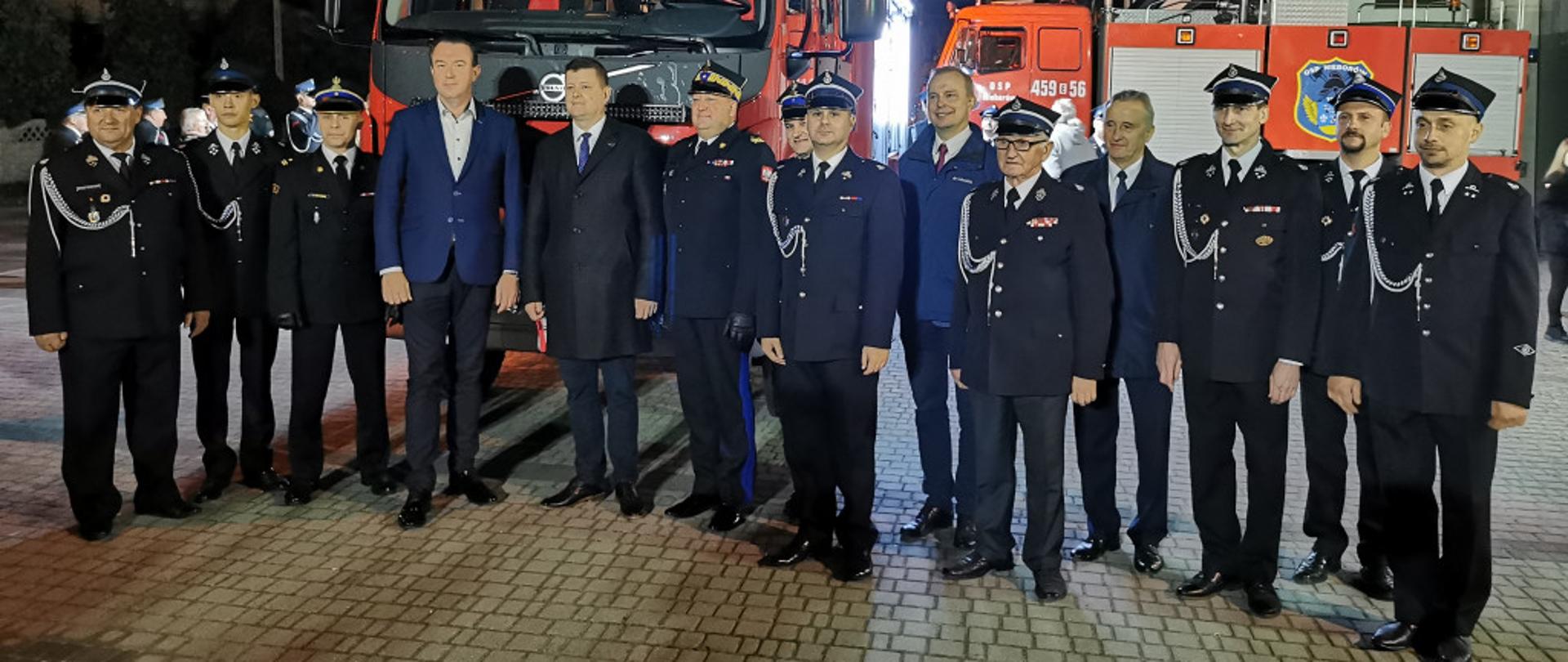 strażacy psp i osp ora mężczyźni w garniturach w tle dwa samochody gaśnicze