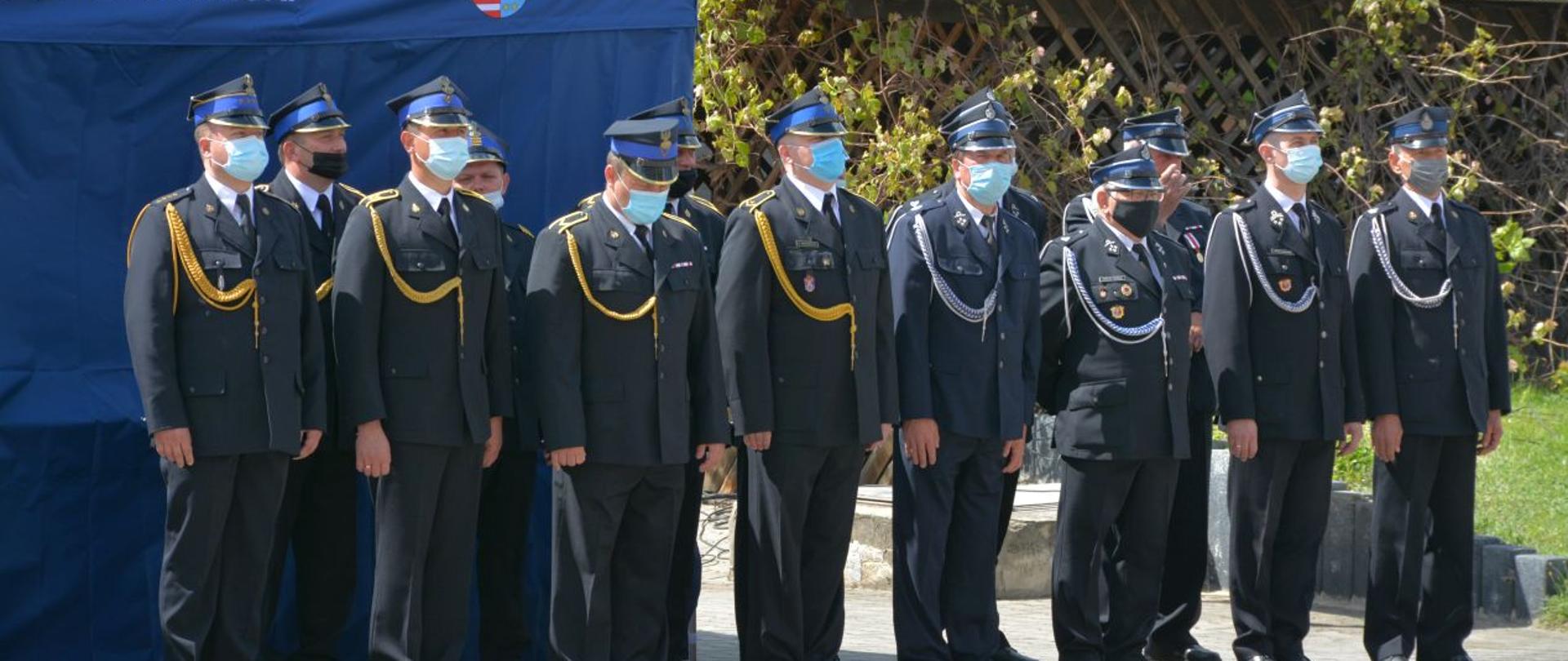 Fotografia przedstawiająca dwuszereg strażaków z PSP oraz OSP.