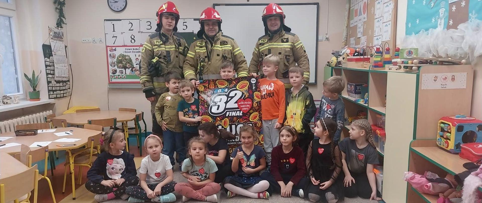 Dzieci i strażacy pozujący do zdjęcia