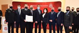 zdjęcie wspólne z przekazaną promesa parlamentarzyści, wicewojewoda, komendant wojewódzki oraz jednostka OSP